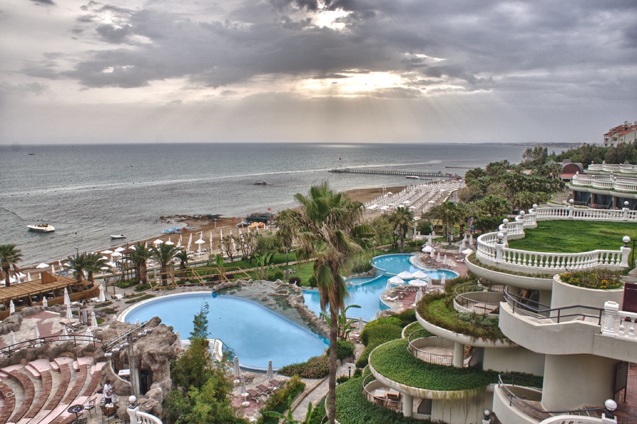 Ağustos ayında Alanya'da güneşli bir günde kalabalık plaj ve turkuaz deniz